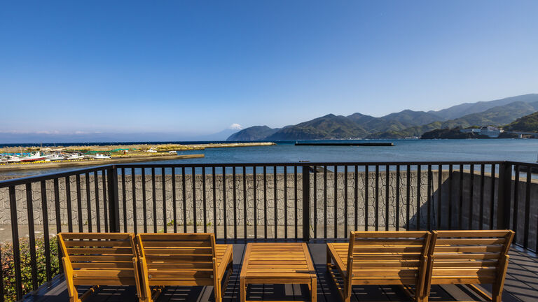 展望デッキに並ぶ木製のベンチと、その先に広がる湾と対岸の山並み