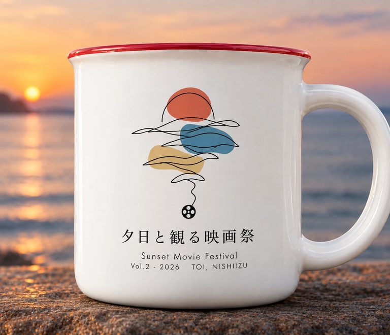 夕日の海辺に置かれた白いマグカップ。太陽と波とフィルムを一本の線で描いたデザインで、縁は赤